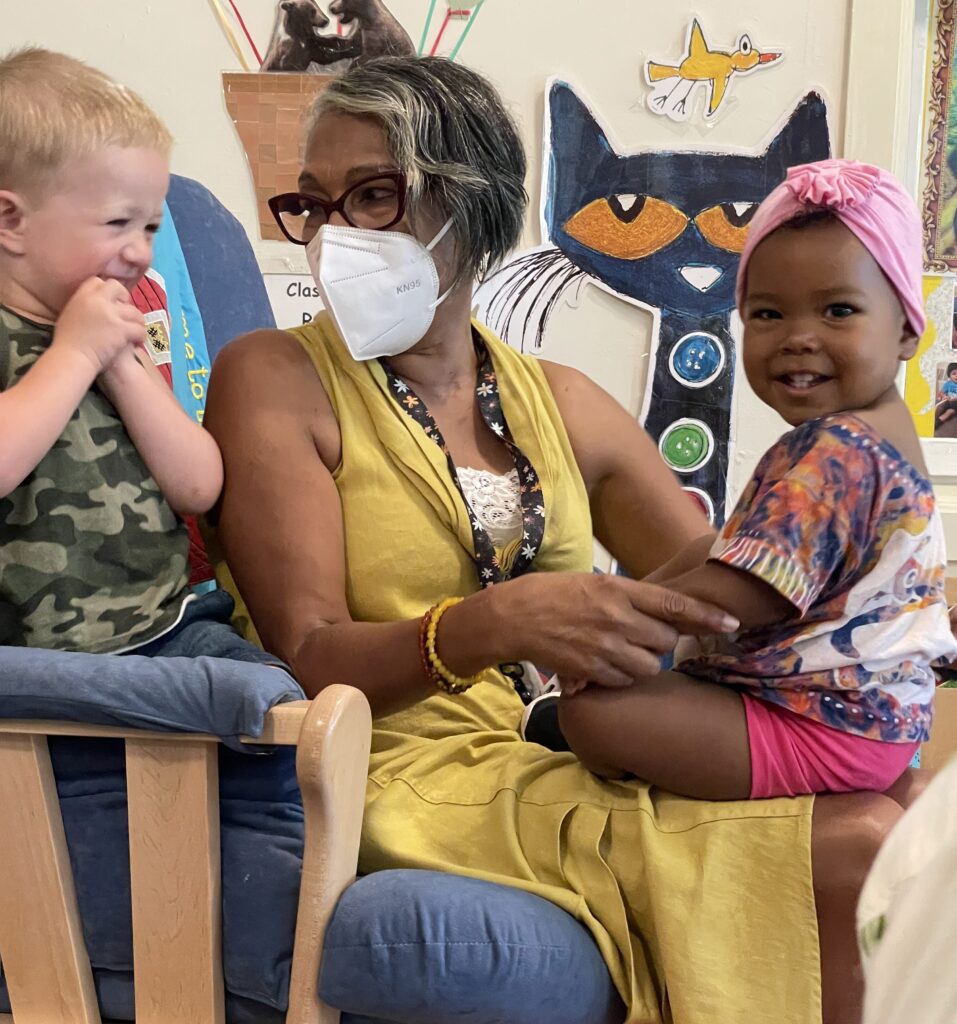 Educator sitting with two toddlers