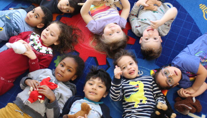 Group of preschool children lying on a rug