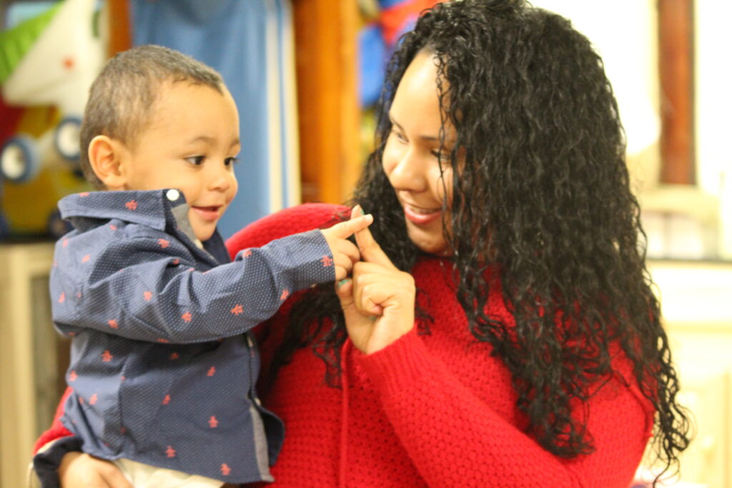 Parent holding and interacting with a toddler