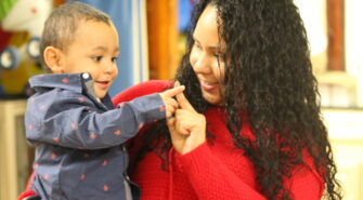 Parent holding and interacting with a toddler