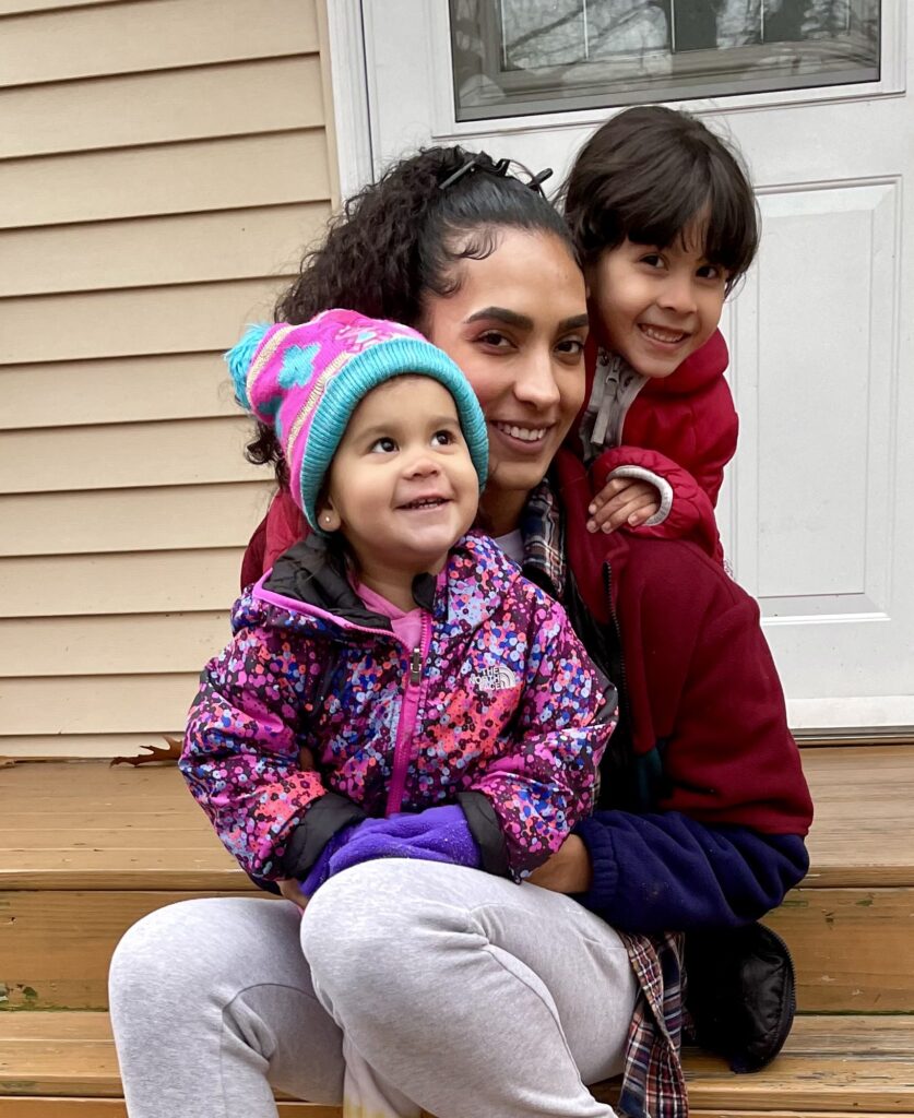 Head Start mother and two young girls on the steps of a family child care home